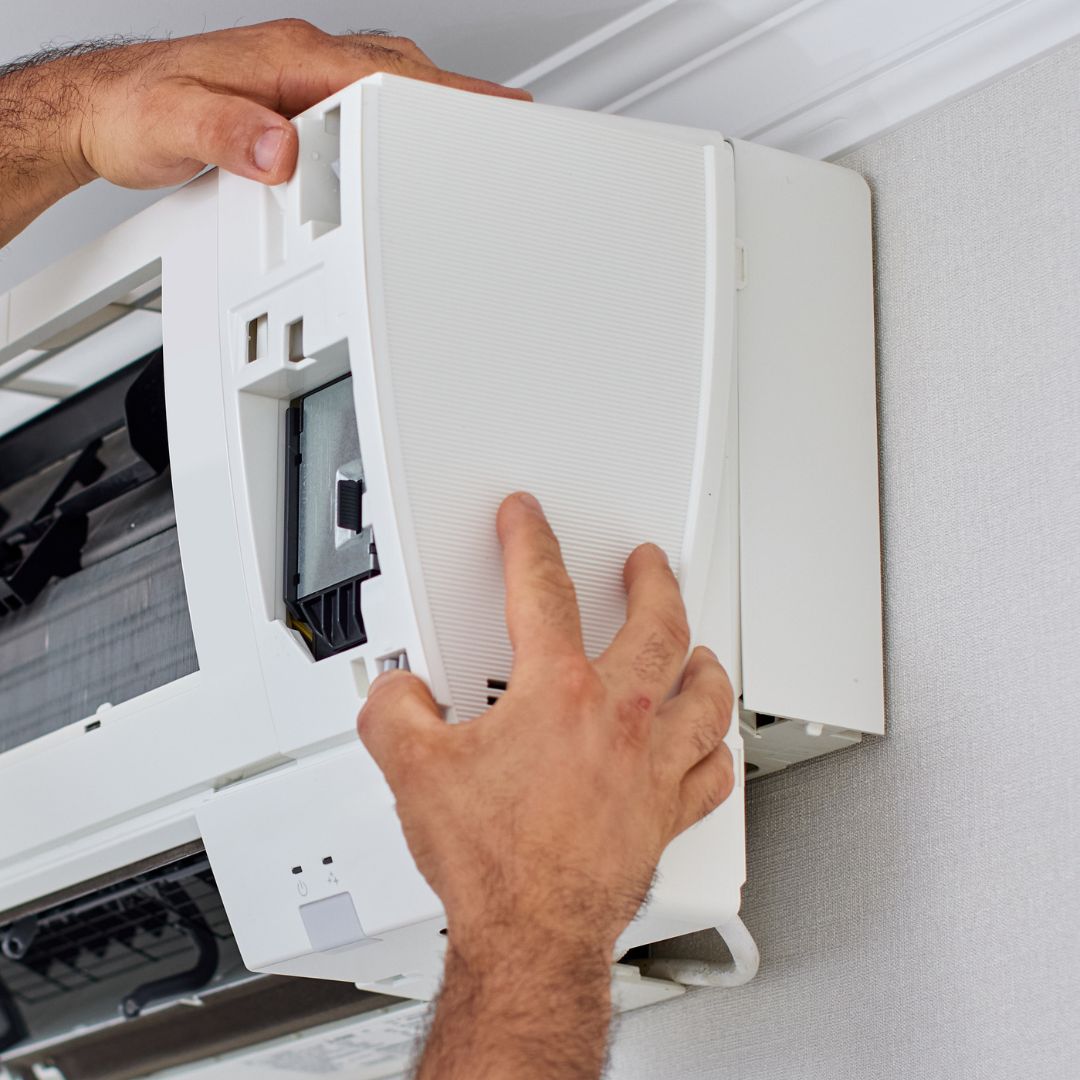 Técnico abrindo unidade interna para manutenção